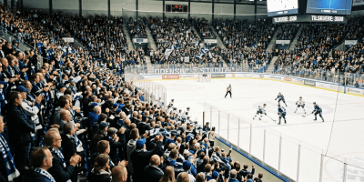 Crowded ice hockey arena with fans cheering and a game in progress