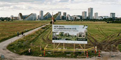 Sign reading “HER SKAL AMAGER PARK BYGGES” and “Fremtidens Bæredygtige Boliger & Fællesskab.”