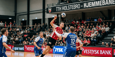 Handball player in red jumps to shoot as defenders in blue block him